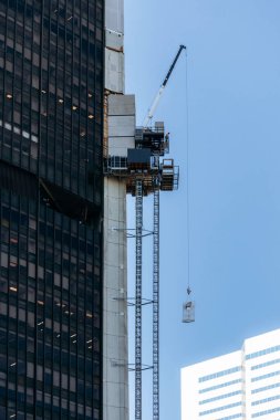 Montreal, Kanada - 11 Ağustos 2025: Montreal şehir merkezinde yenilenmekte olan yüksek katlı bir binanın inşaat iskelesi ve vinci