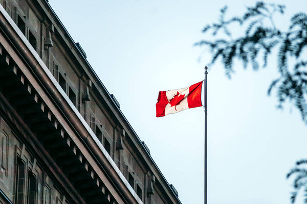 Монреаль, Канада - 11 августа 2025 года: Канадский флаг на фасаде исторического здания в центре Монреаля, Квебек