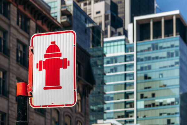 Монреаль, Канада - 11 августа 2025 года: знак пожарного гидранта в центре Монреаля с современными стеклянными зданиями на заднем плане