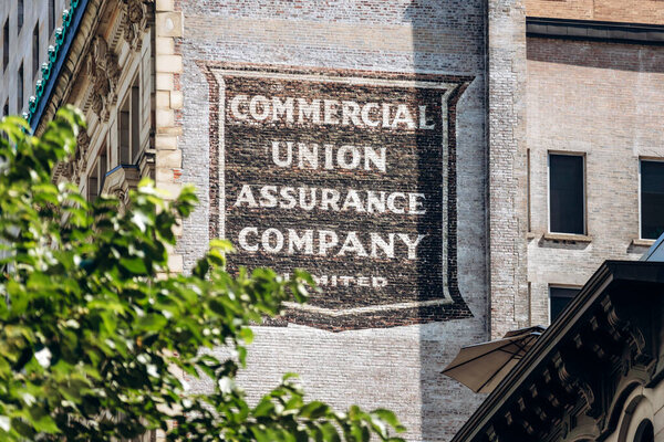 Монреаль, Канада - 11 августа 2025 года: винтажный знак компании Commercial Union Assurance Company на старом кирпичном здании в центре Монреаля