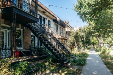 Montreal, Kanada - 12 Ağustos 2025: Montreal 'in Küçük İtalya bölgesindeki konut binalarının dış metal merdivenleri.