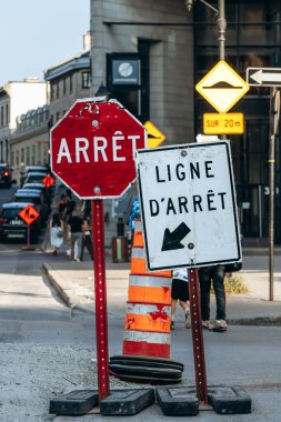 Montreal, Kanada - 13 Ağustos 2025: Montreal şehir merkezindeki sokak sahnesi güneşli bir günde aşınmış dur işaretleri ve yol çalışması unsurlarını gösteriyor
