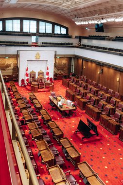 Ottawa, Kanada - 13 Ağustos 2025: Kanada Senato Binası içindeki Senato Odası 'nın iç görünümü, kırmızı halı, oturma yerleri, masalar ve tören tahtları gösteriliyor