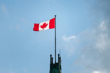 Kanada 'nın ulusal bir sembolü olan Parliament Hill' deki Barış Kulesi 'nin tepesinde dalgalanan Kanada bayrağına yakından bakın.