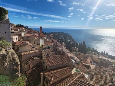 Tepe köyünün panoramik manzarası Roquebrune Cap Martin terracotta çatıları, kilise kulesi ve parlak mavi kış gökyüzü altında Akdeniz