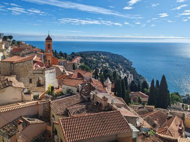 Tepe köyünün panoramik manzarası Roquebrune Cap Martin terracotta çatıları, kilise kulesi ve parlak mavi kış gökyüzü altında Akdeniz