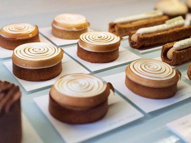 Nice, Fransa - 22 Mart 2025: Nice 'teki ünlü Philippe Tayac pastanesinin vitrininde gösterilen nefis gurme tatlılar