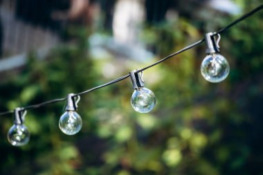 Quebec 'teki Val-Jalbert Tarih Köyü' nün bahçesinde asılı duran yuvarlak ampuller dizisi.