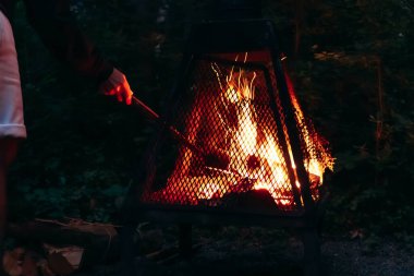 Quebec 'te, Saguenay yakınlarında küçük bir evin yanında kamp ateşi yakan bir adam.