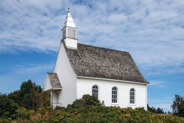 Port-au-Persil, Kanada - 20 Ağustos 2025: Quebec köyünün kırsal kesimindeki Saint Lawrence nehrine bakan çan kulesi olan küçük beyaz ahşap şapel