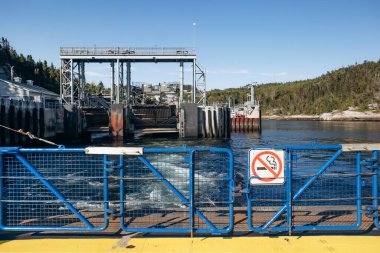 Tadoussac, Kanada - 22 Ağustos 2025: Tadoussac 'taki feribot terminali altyapısı - Baie Sainte Catherine Saguenay Nehri' nden geçerken, metal yükleme rampası, kenetlenme platformu, trafik ışıkları, sigara içilmeyen güvenlik bariyerleri