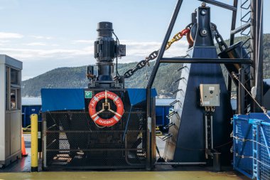 Tadoussac, Kanada - 22 Ağustos 2025: Tadoussac ve Baie Sainte Catherine arasında feribotla yolculuk yapan yolcuları ve araçları St. Lawrence Nehri 'nden geçiren mekanik ekipman ve güvenlik can simidine yakından bakın.