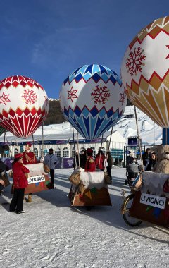 Livigno, İtalya - 15 Şubat 2026: Festivalsel sıcak hava balonu kostümlü göstericiler, Livigno Kar Parkı 'ndaki Milano Cortina 2026 Kış Olimpiyatları mekanında ziyaretçileri eğlendirdiler