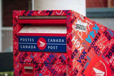 Quebec City, Kanada - 23 Ağustos 2025: Kırmızı Kanada Posta Kutusu Quebec City 'de bir sokakta üzerinde grafik harf tasarımı bulunan
