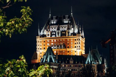 Quebec City, Kanada - 24 Ağustos 2025: Eski Quebec ufuk çizgisine bakan geceleri aydınlatılmış Chateau Frontenac Oteli