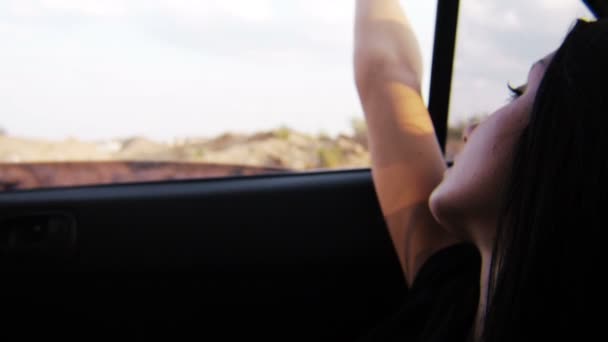 Jeune fille regardant par la fenêtre de la voiture pendant le coucher du soleil à l'arrière-plan 