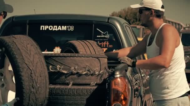 Männer luden Reifen aus Auto — Stockvideo