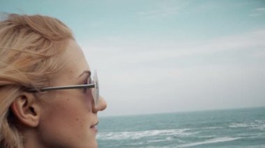 Gülümseyen kız bulutlu rüzgarlı gün plaja yavaş hareket yakın yürüyüş