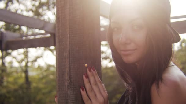 Junges Mädchen blickt im Sommer in die Nähe der Holzstange — Stockvideo