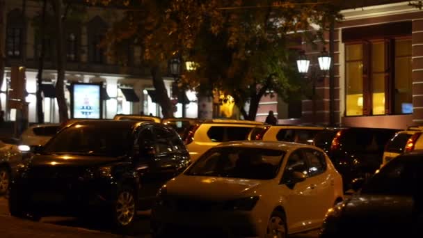 Beleuchtete Straßen und Gebäude, nächtliches Parken mit Autos — Stockvideo