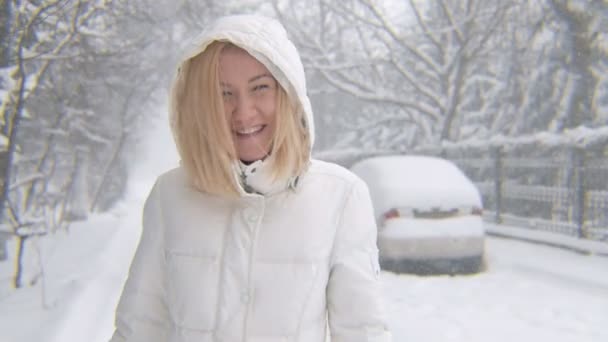 Ξανθό κορίτσι με τα πόδια, χαμογελώντας στην κρύα ημέρα του χειμώνα — Αρχείο Βίντεο