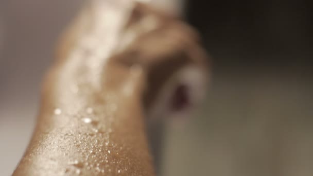 Gotas de agua en la piel en cámara lenta sobre un fondo blanco bañador — Vídeo de stock