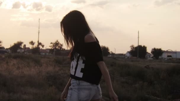 Silhouette della ragazza in pantaloncini che gira durante il tramonto — Video Stock