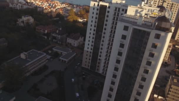 Mujer rubia mirando hacia abajo a los edificios altos desde el piso alto — Vídeo de stock