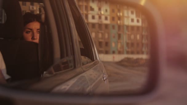 В зеркале заднего вида сидит девушка в машине — стоковое видео