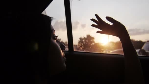 Молода дівчина дивиться з вікна автомобіля — стокове відео