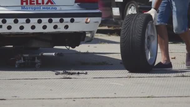 ODESSA, UCRANIA - 13 DE JULIO DE 2015: Tornillo mecánico del coche o desenroscar la rueda del coche levantado por llave — Vídeo de stock