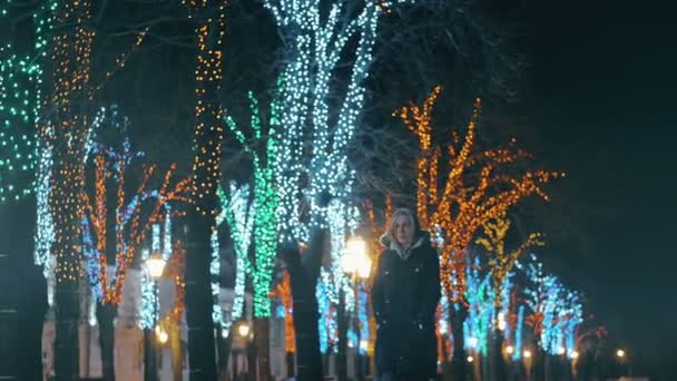 Жінка ходить на веселих і освітлює вулиці в Різдво — стокове відео