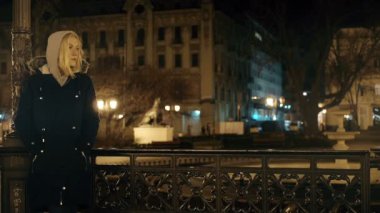 Neşeli üzerinde bekleyen kadın ve aydınlatır sokaklar Noel