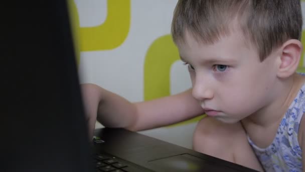 Μικρό αγόρι παίζει στα παιχνίδια υπολογιστή με σοβαρά πρόσωπο — Αρχείο Βίντεο