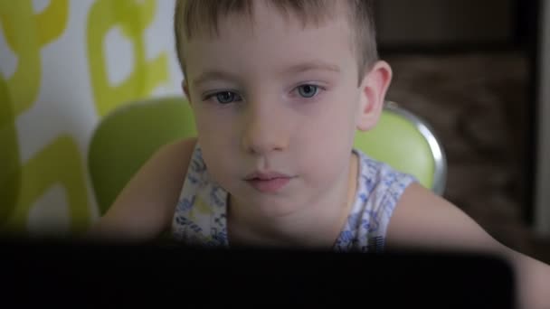 Kleiner Junge spielt mit ernstem Gesicht an Computerspielen — Stockvideo