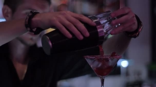 Рука бармена с шейкером, наливающим коктейль в стакан — стоковое видео