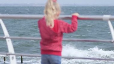 Genç sarışın kız bak sahilde, denizde gülümseyen ve geriye dönüp baktığımda