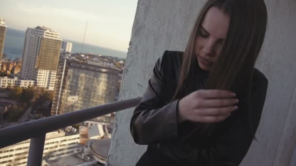 Blond kvinna sola i filt på hög våningen på byggnader bakgrund — Stockvideo