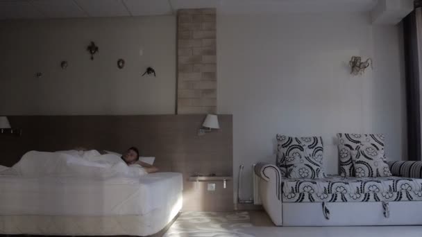 Hombre durmiendo en la cama en un apartamento de lujo — Vídeos de Stock