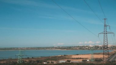 Sarışın buğday alanlarında ve arka plan bir gölde eski elektrik direkleri