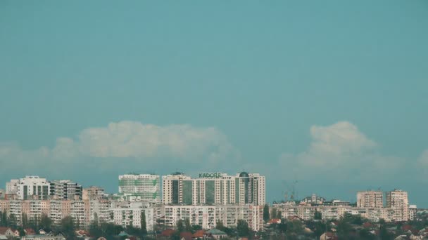 Pylonen voor de oude elektriciteit in velden en een meer met gebouwen op achtergrond — Stockvideo