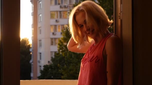 Blondes Mädchen genießt die Sonne lächelnd, wenn ein Sonnenstrahl durch den Sonnenuntergang bricht — Stockvideo