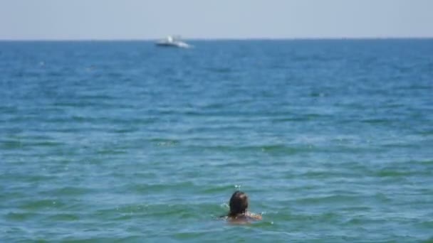 Flicka bandy i havet där katamaran båt på bakgrunden suddig — Stockvideo