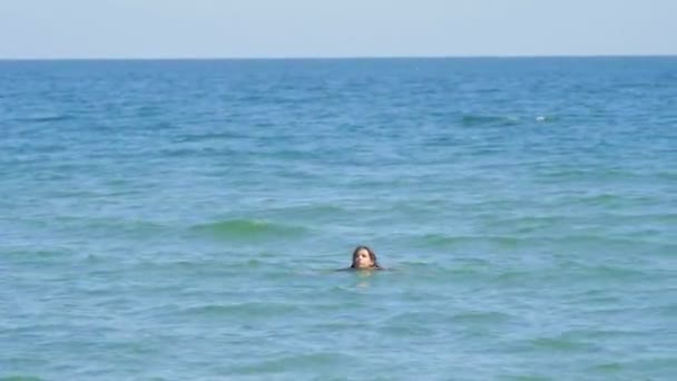 Niña nadando en el mar donde barco catamarán en el fondo borrosa — Vídeo de stock