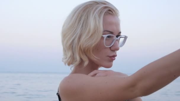 海滩比基尼的金发女孩以自拍照智能手机是面带笑容快乐 — 图库视频影像