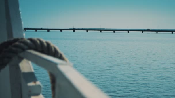 Legare le corde della barca con un ponte sotto il mare sullo sfondo — Video Stock