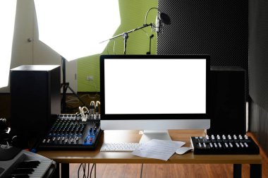 Kayıt odasındaki sesi kontrol etmek için kullanılan bilgisayar masası mikrofon ve müzik ekipmanıyla donatılmış..