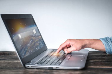 Masadaki bilgisayara işaret eden bir jest gösteren kot gömlek giyen bir adamın eli beyaz bir arka plan, iş konsepti, teknoloji konsepti....