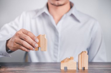 Emlakçı, emlak, taşınma ya da kiralama gibi emlak sözleşmelerini imzaladıktan sonra müşterisiyle takas etmek için ahşap bir ev tutuyor..