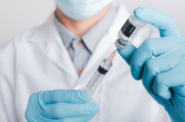 Doktorlar cerrahi maske ve gözlük takıyor, bilim adamları, bilim adamları COVID-19 için şırınga ve aşı, aşı ve laboratuvar deneyleri tutuyor. Virüs koruma kavramı COVID-19,